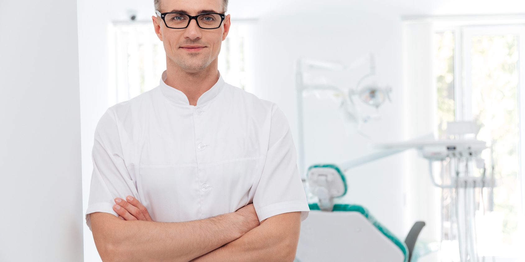 Female dentist standing with his hands crossed